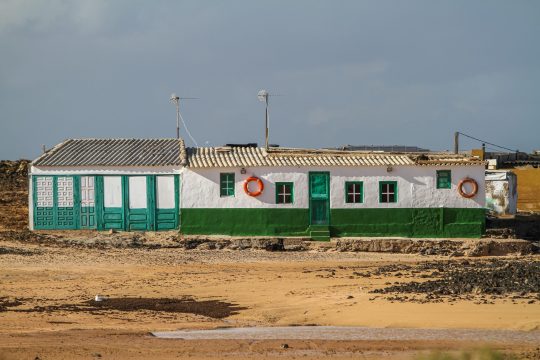 A white and green building in the middle of a field in Fuerteventura, Canary Islands